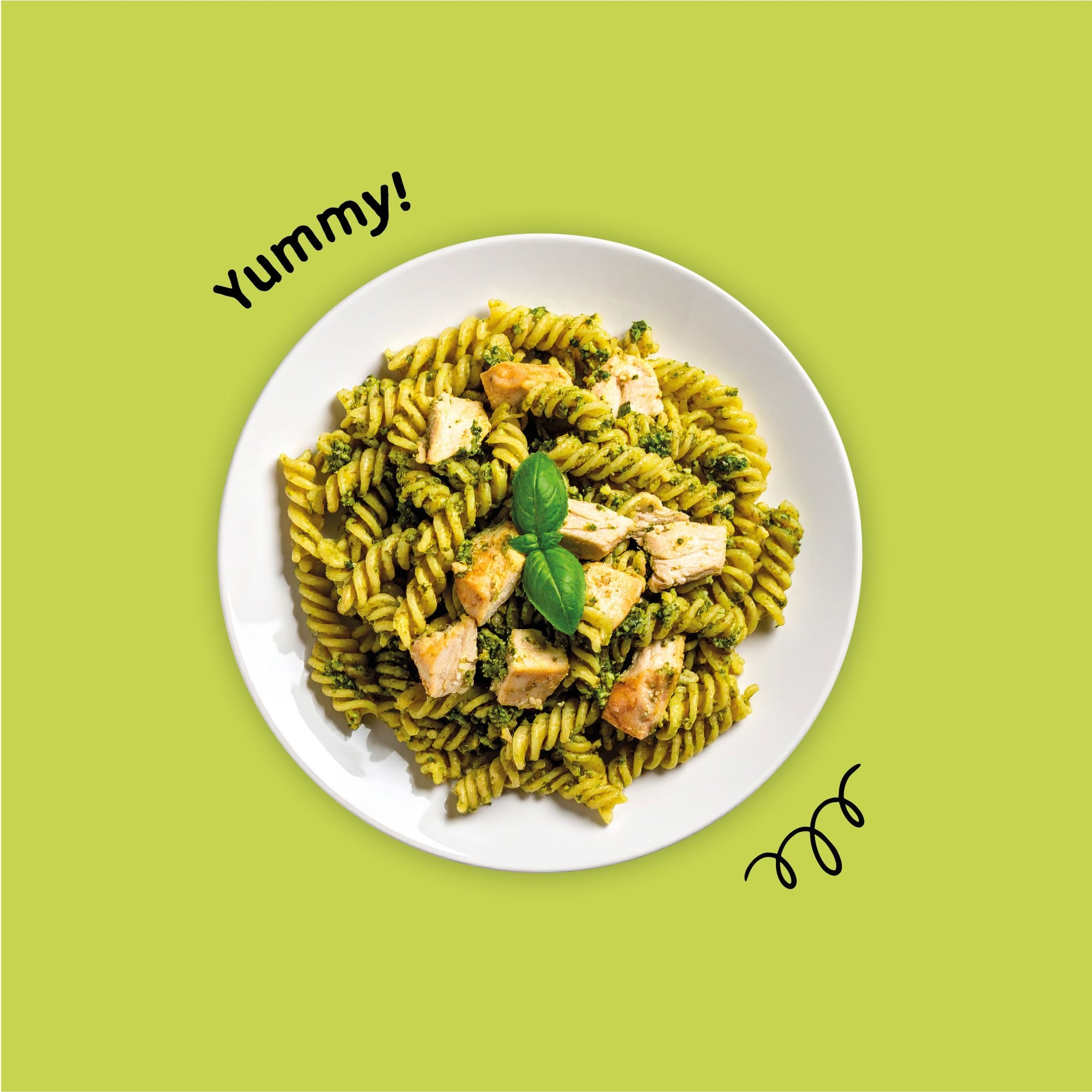 Gluten-free pasta with chicken and basil on a white plate against a green background