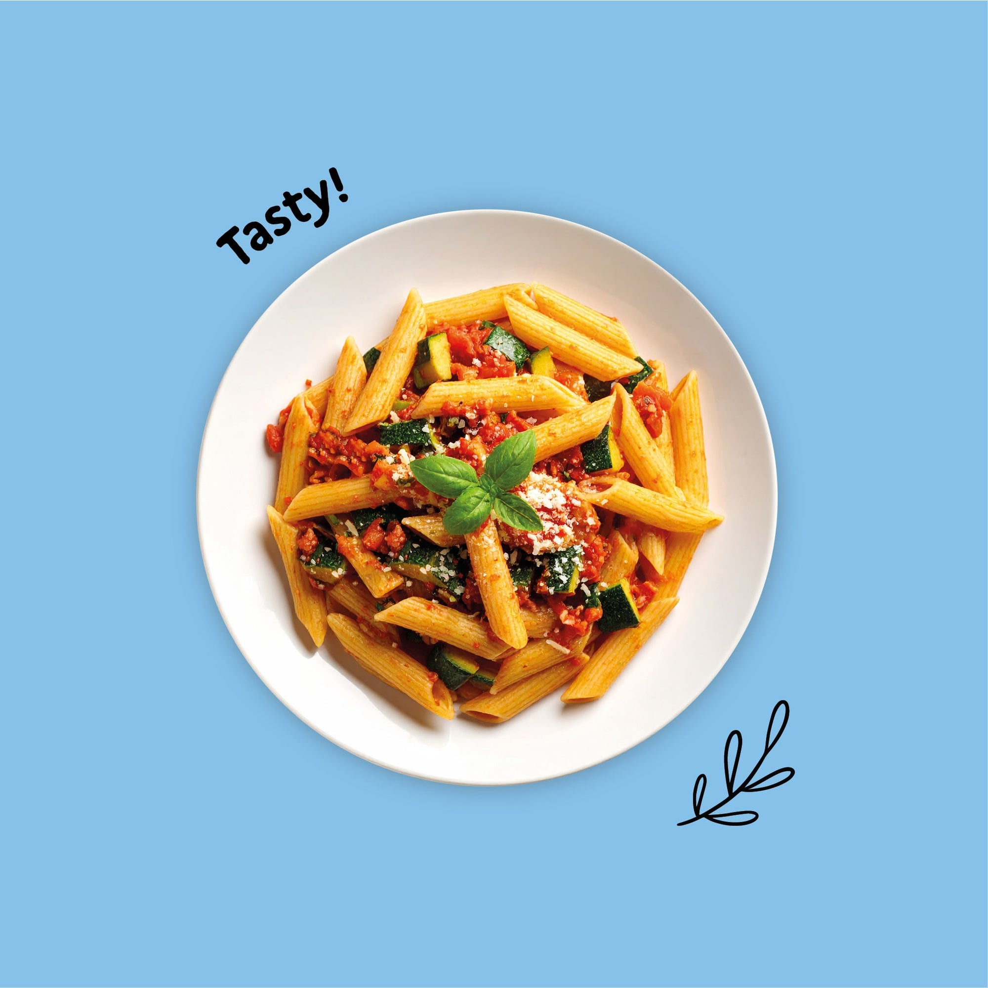 Gluten-free pasta with zucchini and puttanesca sauce on a white plate against a blue background