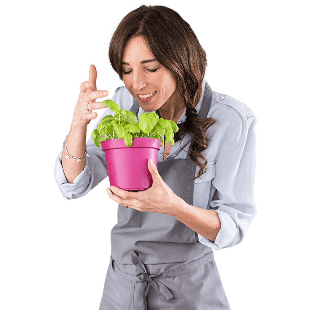 Our founder Chiara holding a pink pot with basil plant.